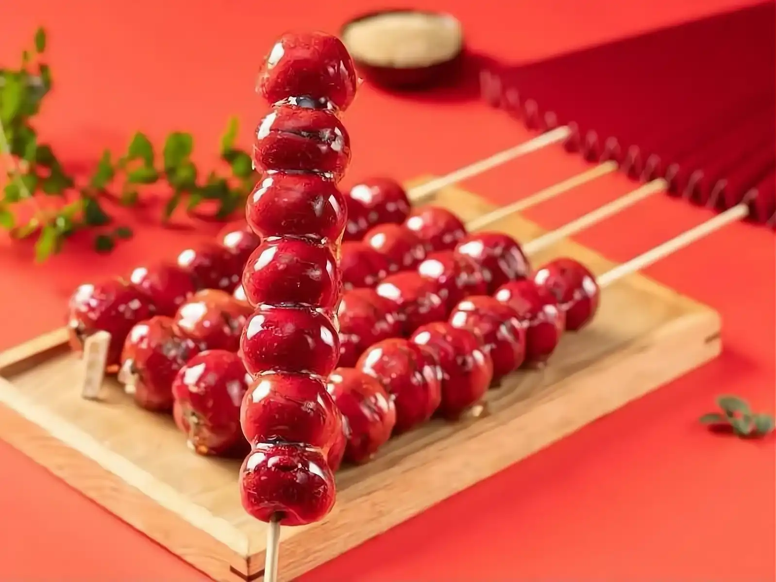 Bright red candied hawthorns on bamboo skewers, glistening with crystallized sugar coating